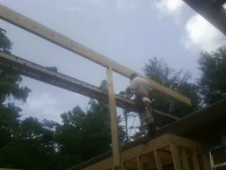 Carpenter setting a ridge beam over a new addition frame — Ice Dam Removal by Roofing Brothers in Villas