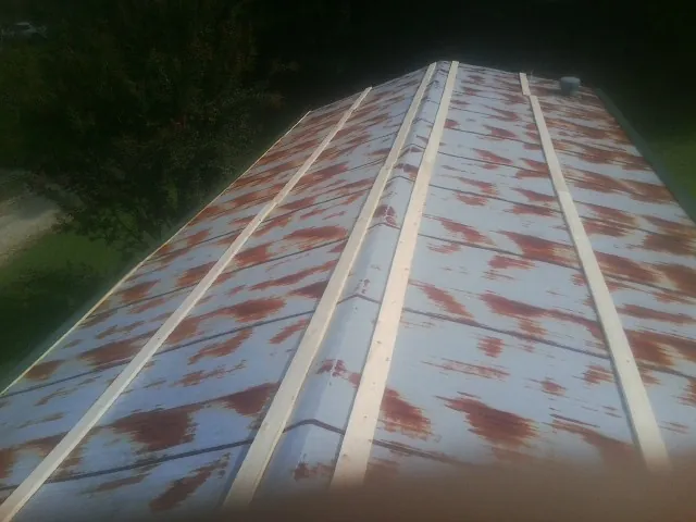 Rusted metal roof panels with new wood purlins before replacement — Storm Damage Roof Repair in Villas by Roofing Brothers