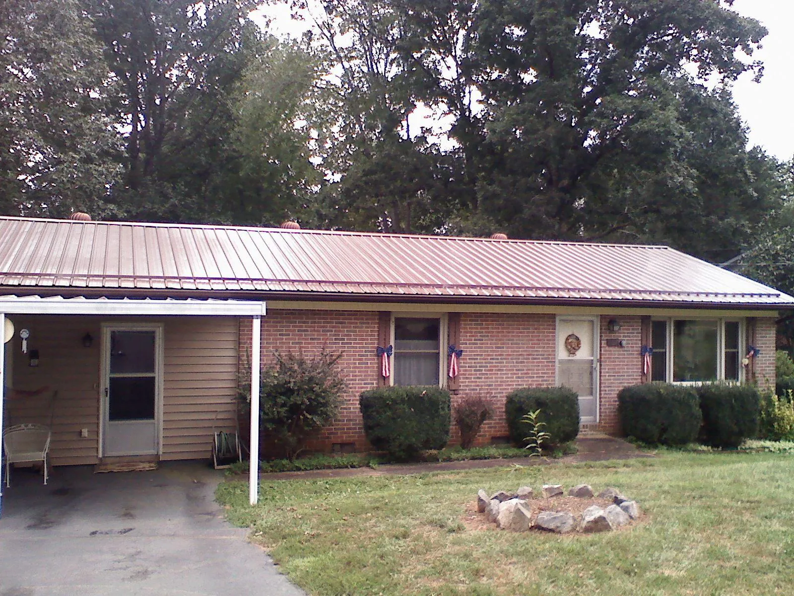 Bronze metal roof and carport on a brick ranch home — Roof Repair work by our crew in Villas